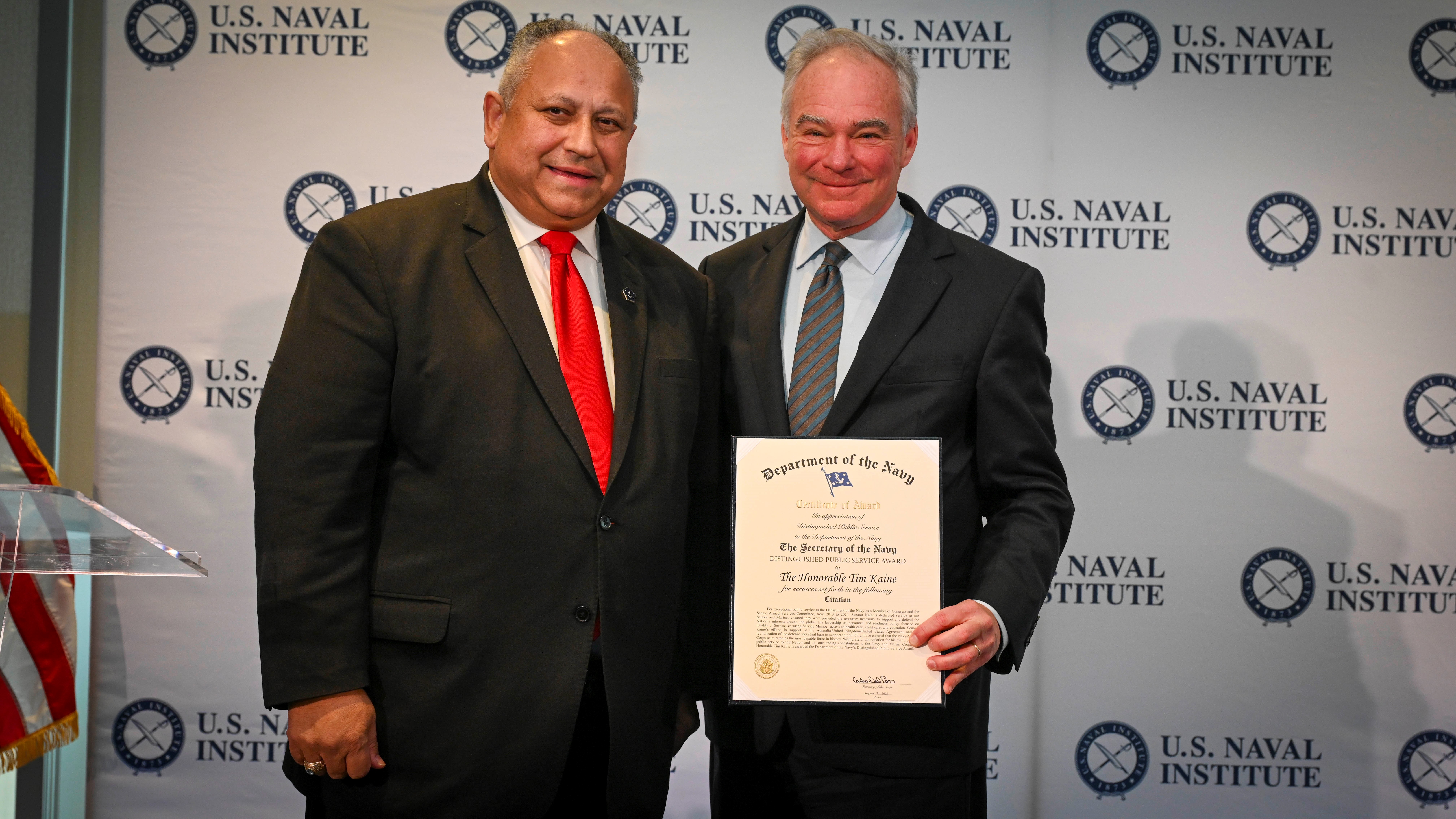 Senator Kaine poses for a picture with Secretary of the Navy, Carlos Del Toro, while holding his Distinguished Public Service Award. 