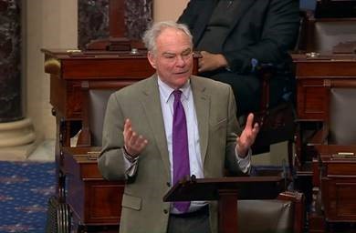 Senator Kaine speaking on Senate floor in front of lectern.